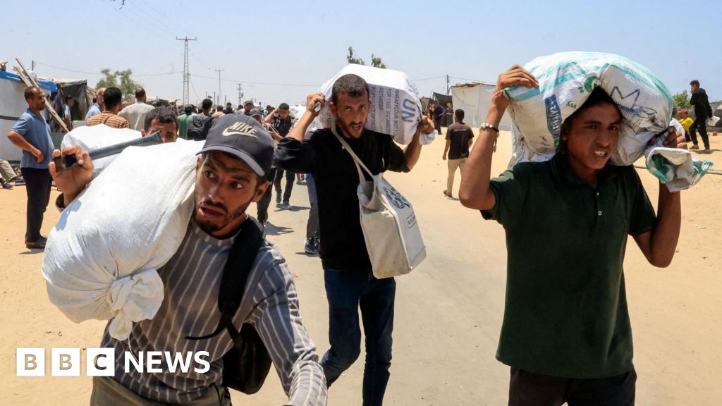 Palestinians say that local gunmen and Israeli forces set fire to Gaza aid site